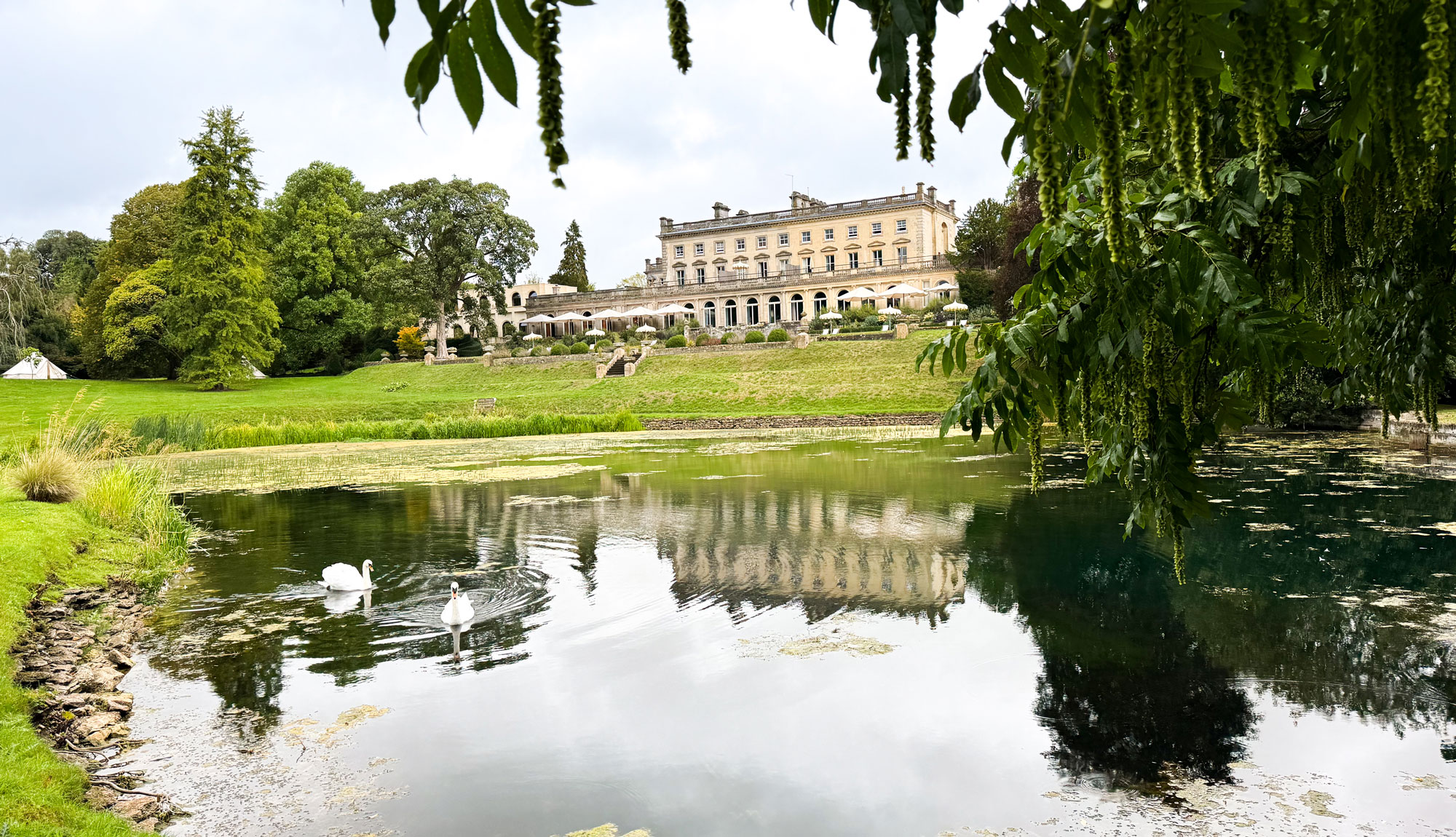An image of Cowley Manor and the lake behind it
