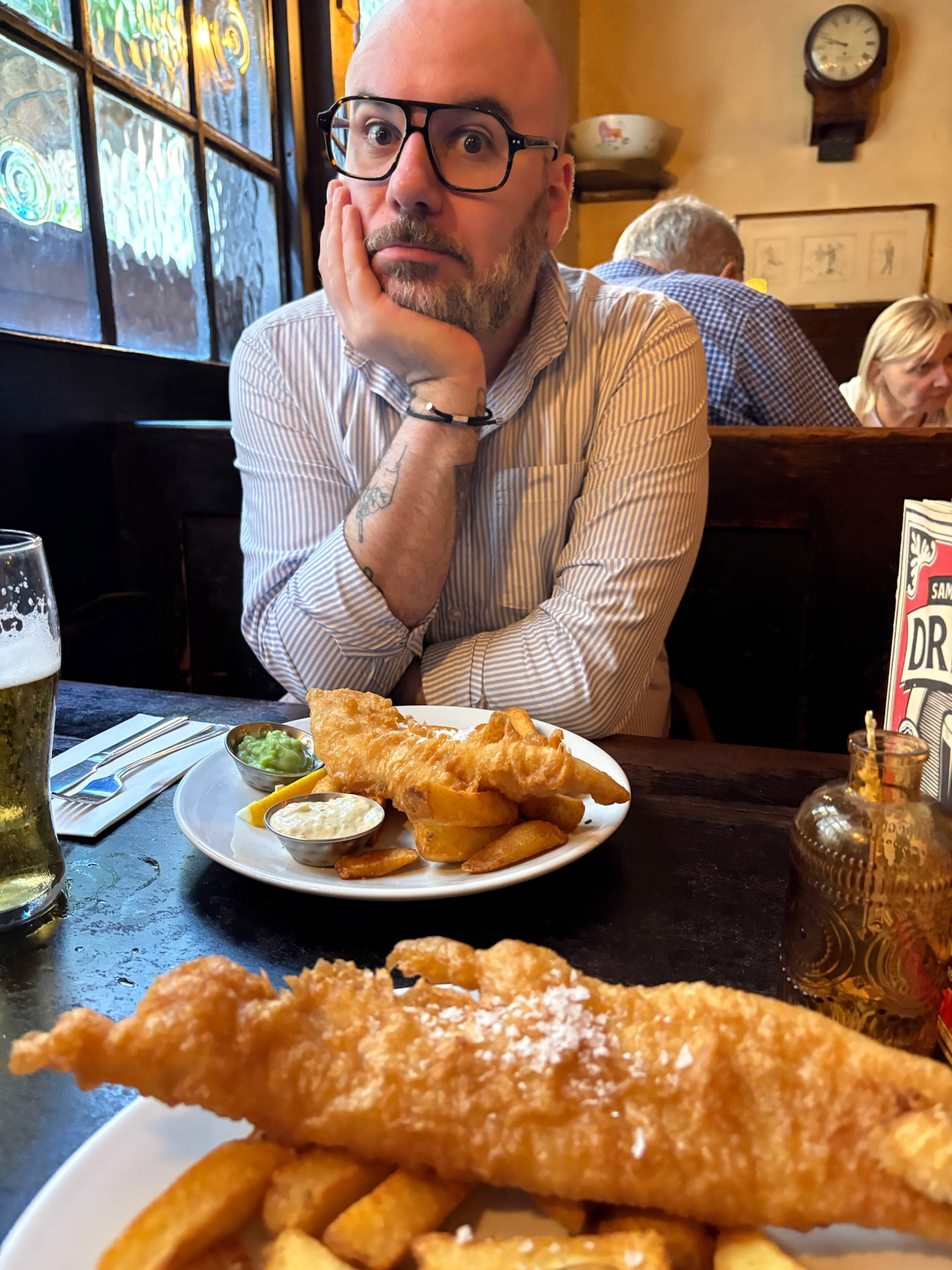 Photo of Kyle sitting in front of two baskets of fish and chips