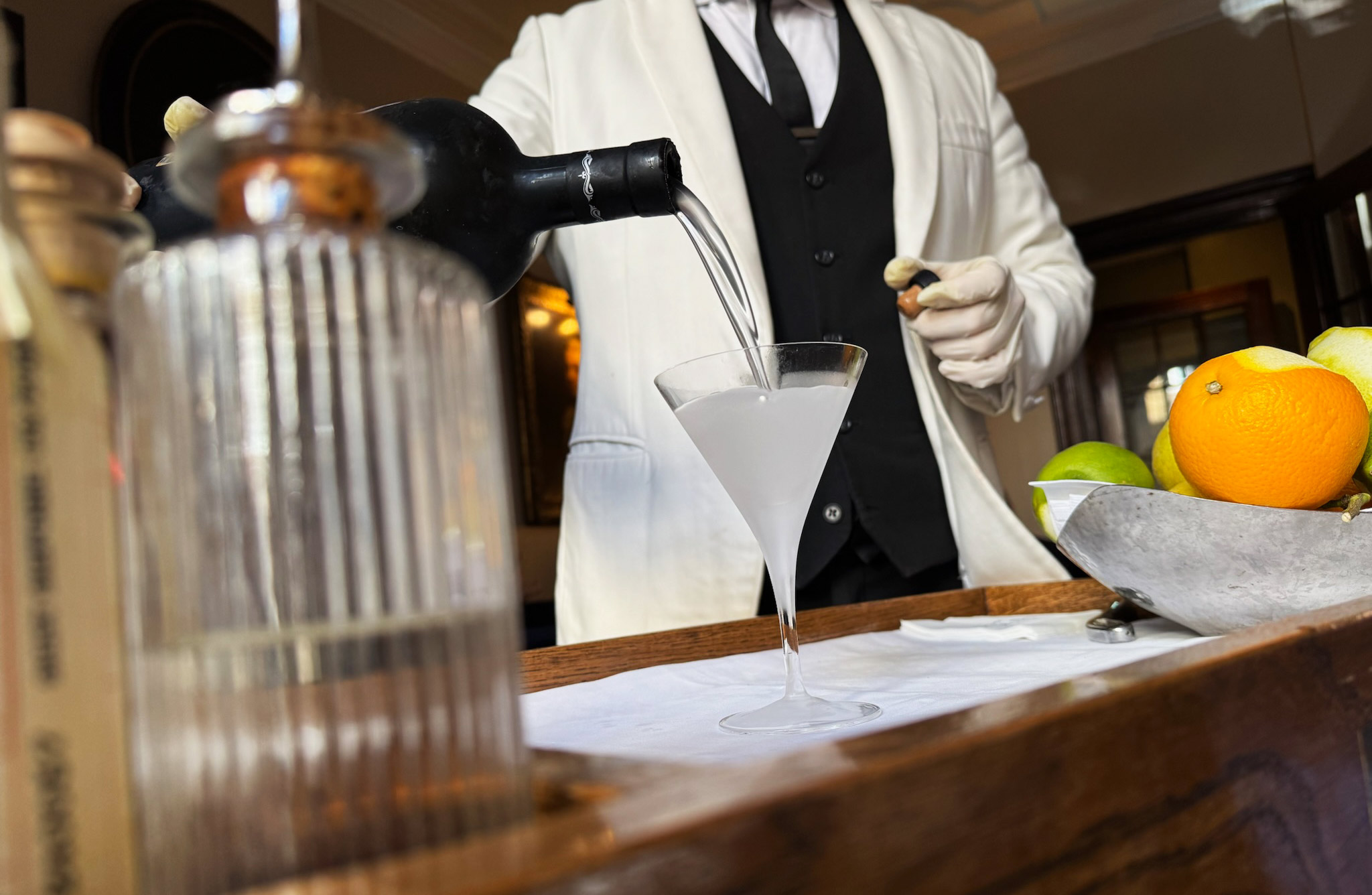 An image of a bartender pouring a gin martini at Dukes Bar